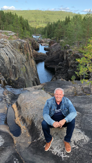 Jim standing near a rocky waterfall